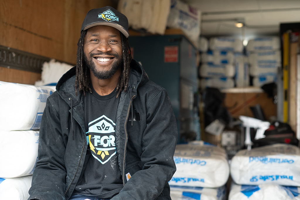 WxForce crew technician sitting next to insulation in a trailer