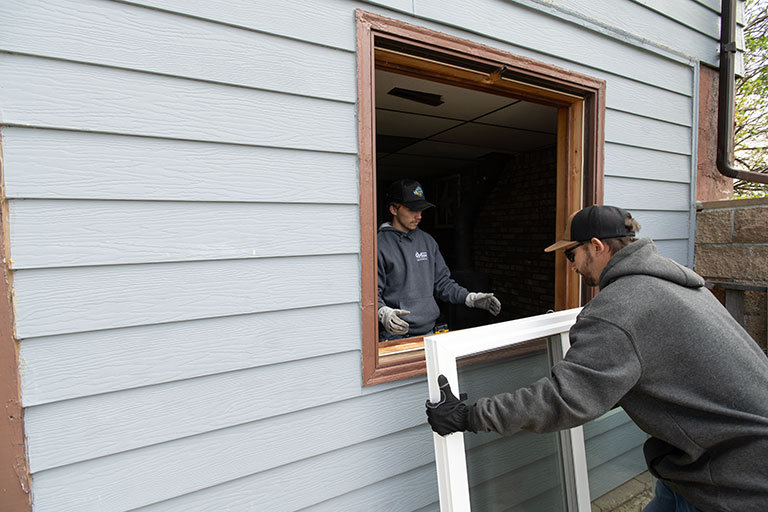 two workers installing a window