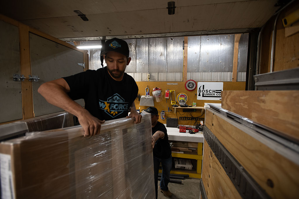 worker in trailer carrying weatherization materials