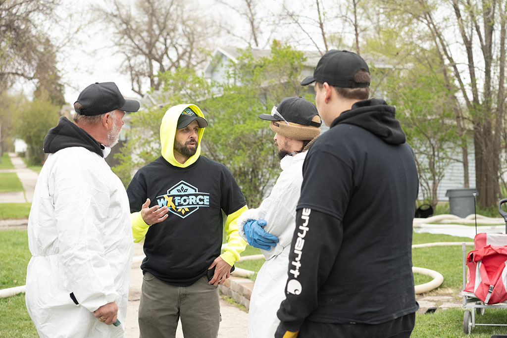 four WxForce team members standing near each other discussing detaails of the job