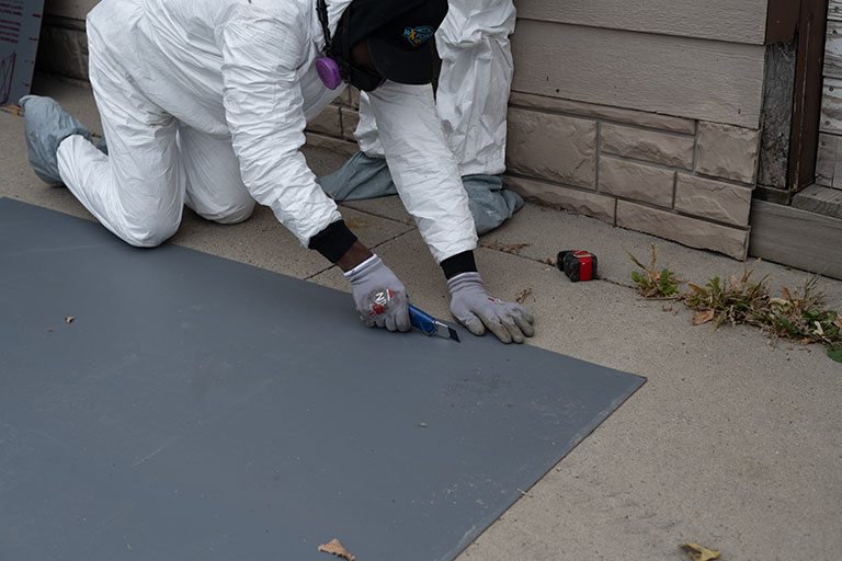 worker cutting a weatherization material