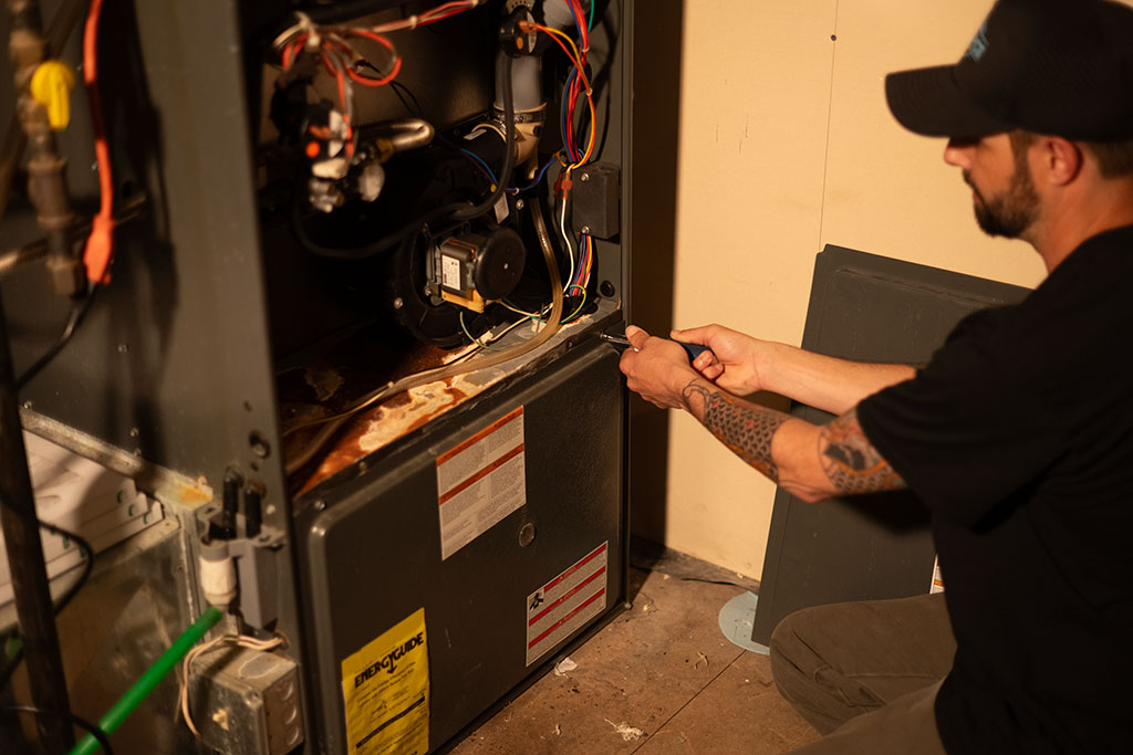 worker making repairs to a furnace